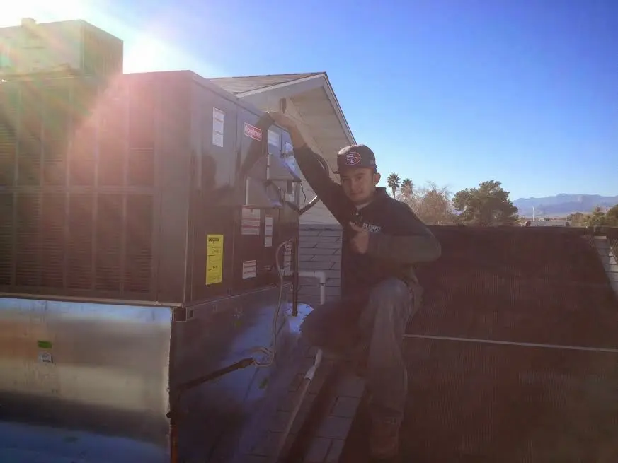 HVAC technician performing AC Tune-Up on a rooftop unit in Mount Dora